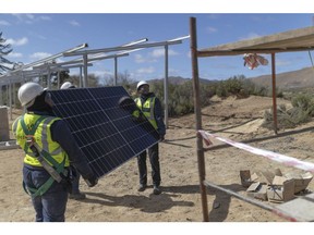 Workers install a solar panel on a farm in Groenfontein, South Africa. Photographer: Guillem Sartorio/Bloomberg