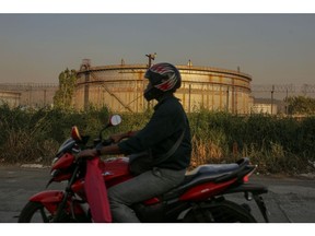 A motorcyclist rides past an oil refinery, operated by Bharat Petroleum Corp. Ltd., in Mumbai, India, on Saturday, Dec. 10, 2022. A senior official at India's oil ministry told reporters this month India has been buying oil from about 30 countries, and will continue to buy from anywhere including Russia beyond January.