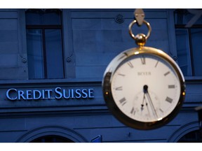The Credit Suisse Group AG headquarters logo beyond a clock in Zurich, Switzerland, on Tuesday, March 21, 2023. Recruiters across the world are getting an unprecedented flood of calls from Credit Suisse Group AG bankers seeking new jobs as the embattled Swiss lender is set to be taken over by UBS Group AG. Photographer: Stefan Wermuth/Bloomberg
