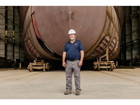 Eco Edison project manager Whit Carter stands in front of the boat under construction.  Photographer: Bryan Tarnowski/Bloomberg