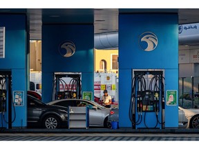A worker refuels vehicles on the forecourt of an Abu Dhabi National Oil Co. (ADNOC) gas station in the Jumeirah district of Dubai, United Arab Emirates, on Thursday, April 20, 2023. Abu Dhabi's main energy company ADNOC raised $2.5 billion from the initial public offering of its gas business, pulling off the year's biggest listing and continuing a trend that saw the Middle East emerge as a bright spot for share sales in 2022.