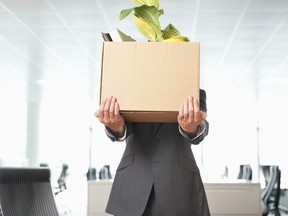 Worker carries box of belongings out of office