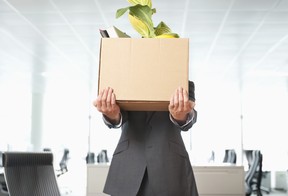 Worker carries box of belongings out of office