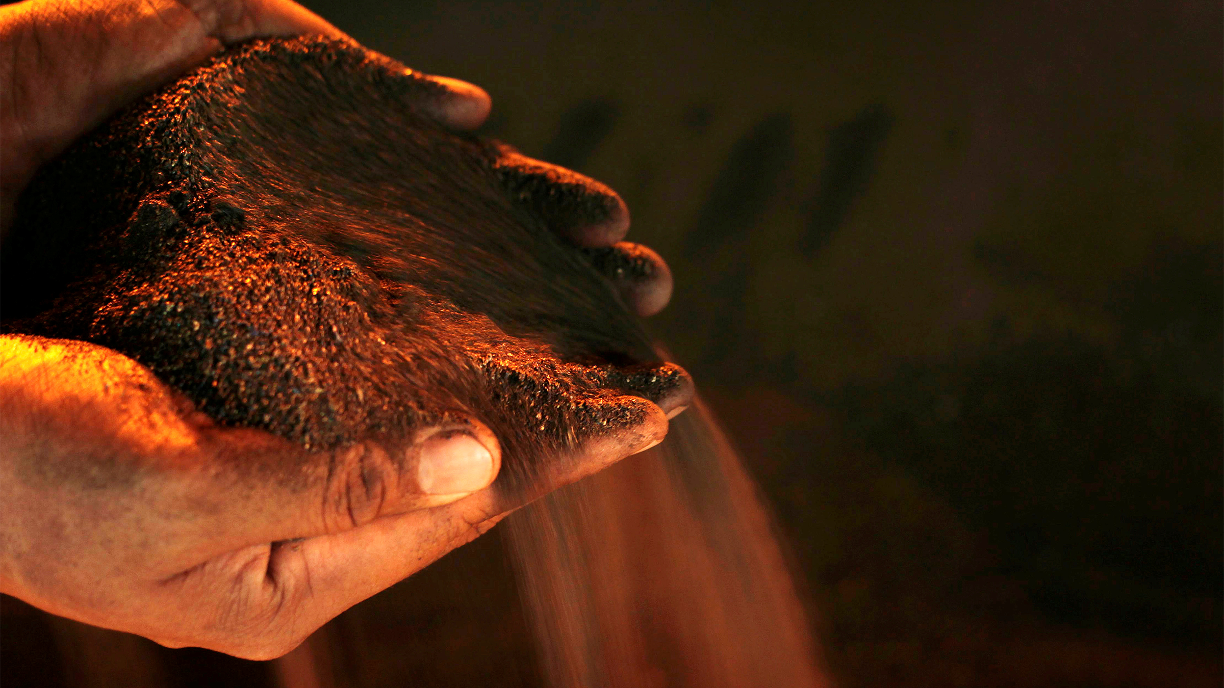 Processed nickel runs through a person's hands.