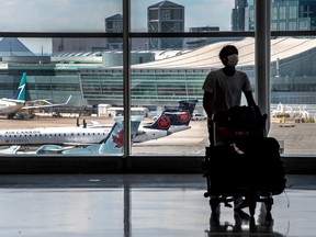 A traveller at Toronto's Pearson Airport walks past Air Canada planes.