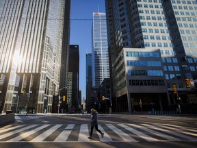 A pedestrian crosses the street in Toronto's financial district. Lenders appear to be working with their customers to avoid costly bankruptcies.