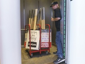 A staff member of the Writers Guild of America, WGAW readies placards at their offices after failed negotiations with studios, Tuesday, May 2, 2023, in Los Angeles. Late-night shows including "The Tonight Show" and "The Daily Show" immediately went dark and screenwriters were set to begin picketing as the Writers Guild went on strike Tuesday after last-minute negotiations failed to avert Hollywood's first work stoppage in 15 years.