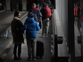 People make their way through Pearson Airport in Mississauga, Ont., on Tuesday, March 14, 2023. A new survey ranks Canada's two biggest airlines below the average for customer satisfaction among major North American carriers.