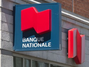 National Bank of Canada raised its quarterly dividend and reported its second-quarter profit fell compared with a year ago as it faced higher non-interest expenses and increased provisions for bad loans. A National Bank sign is seen May 30, 2016 in Montreal.