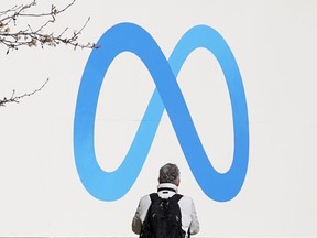 A person in front of the Meta logo.