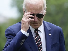 President Joe Biden removes his sunglasses as he walks to speak with reporters after returning to the White House in Washington, Sunday, May 28, 2023. Biden and House Speaker Kevin McCarthy came to an "agreement in principle" on the debt limit Saturday that would avert a potentially disastrous U.S. default, but still has to pass both houses of Congress.