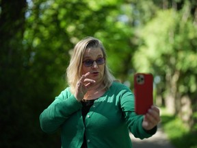 Lisa Anderson, who is deaf, communicates with American Sign Language (ASL) with her friend Leanor Vlug while on a video call on her iPhone, in Burnaby, B.C., on Friday, May 19, 2023. There's a sense of worry that creeps up on Anderson every time her phone alerts her she is near the end of her monthly data limit. For her each megabyte of data is more crucial than it would be for the average hearing person who doesn't rely on video calling applications for every mobile conversation.