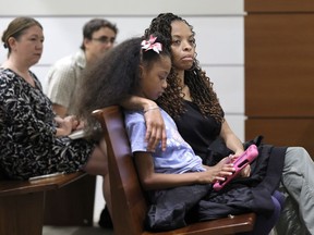 Philana Holmes and her daughter Olivia Caraballo, 7 listen to the final witness in their case at the Broward County Courthouse in Fort Lauderdale, Fla., on Wednesday May 10, 2023. McDonald's and a franchise holder are at fault after a hot Chicken McNugget from a Happy Meal fell on the girl's leg and caused second-degree burns, a jury in South Florida has found, Thursday, May 11.