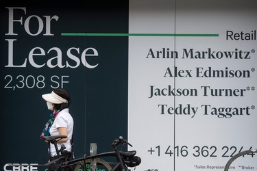 A pedestrian walks past commercial space for lease in downtown Toronto. Office vacancy rates are high in Canada's downtown cores.