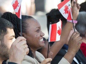 Attendees at a citizenship ceremony in Ottawa wave Canadian flags. The federal government says it will be targeting carpenters, plumbers, health-care professionals and French speakers from abroad this summer for immigration to Canada.