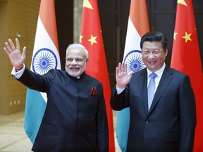 India’s prime minister Narendra Modi, left, and China’s president Xi Jinping wave to journalists in China, in 2015.