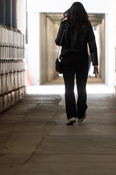 A pedestrian walks through a construction tunnel on Toronto's King Street West.