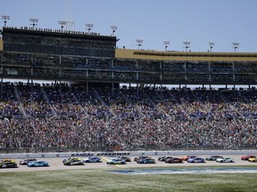 Drivers head down the front straightaway at the start of a NASCAR Cup Series auto race at Kansas Speedway in Kansas City, Kan., Sunday, May 7, 2023.