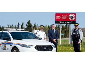 MADD Canada and the Government of Prince Edward Island are teaming up to encourage the public to call 911 to report suspected impaired drivers to police. Pictured here (left to right): PEI RCMP Criminal Operations Officer Kevin Lewis, MLA for Charlottetown-Winsloe MLA Zack Bell, and PEI RCMP Cst. Stephen Duggan unveil a new Campaign 911 sign on westbound Route 2 towards Kensington, past Sherwood Road in Winsloe (Queens County). It is one of 30 signs going up across the province.