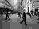 People walk along Wall Street by the New York Stock Exchange.