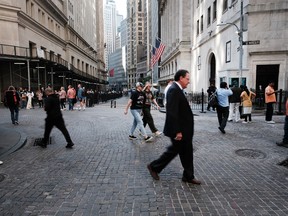 People walk along Wall Street by the New York Stock Exchange.
