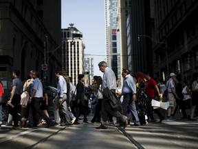 Pedestrians cross a street in the financial district of Toronto.