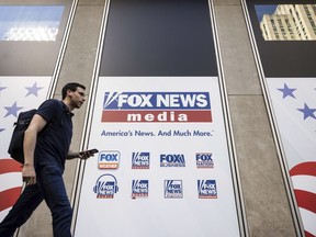 FILE - A person walks past the Fox News Headquarters in New York on April 12, 2023. Fox Corp. swung to a third quarter loss Tuesday, May 9, weighed down by Fox News' nearly $800 million settlement with Dominion Voting Systems.