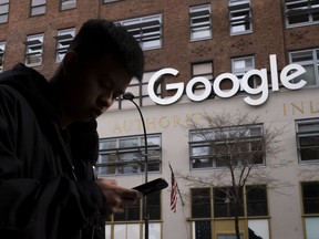 FILE - A man using a cell phone walks past Google offices on Dec. 17, 2018, in New York. Attorneys debated the proper jurisdiction for settling a legal challenge to the first-in-the-nation tax on digital advertising during arguments before Maryland's highest court on Friday, May 5, 2023. Attorneys for Big Tech companies like Facebook, Google and Amazon have contended the law unfairly targets them.