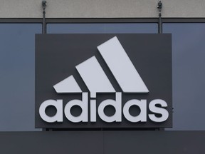 FILE - A sign is displayed in front of an Adidas retail store in Paramus, N.J., Oct. 25, 2022. After months wrestling over the fate of millions of unsold Yeezy shoes, Adidas has decided to sell a portion of its remaining inventory and donate the proceeds to charitable organizations, CEO of the German sport brand Bjørn Gulden said Thursday, May 11, 2023.