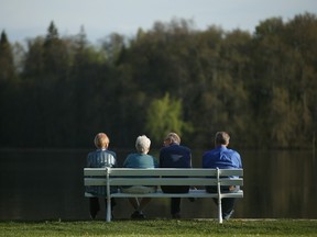 Four elderly people on a park bench