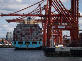 Cargo containers are unloaded from the Maersk Stockholm ship with gantry cranes while docked at port, in Vancouver, on Tuesday, April 25, 2023. The Vancouver Fraser Port Authority says overall cargo volumes fell by three per cent last year, as the global economy began to show signs of a slowdown.