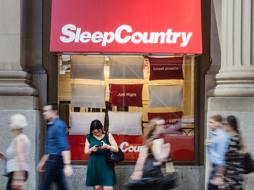  pedestrians walk past a sleep country store in toronto.