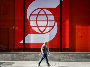 Person walks in front of Scotiabank logo