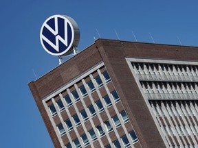 FILE - The Volkswagen logo stand on the top of a VW headquarters building in Wolfsburg, Germany, Monday, April 27, 2020. Volkswagen profits fell 30% in the first three months of the year despite booming business in Europe and North America because sales dropped in China, where the German automaker is facing increasing competition from homegrown models.