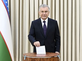 In this handout photo released by Uzbekistan's Presidential Press Office, Uzbekistan's President Shavkat Mirziyoyev casts his ballot at a polling station during a referendum in Tashkent, Uzbekistan, Sunday, April 30, 2023. Voters in Uzbekistan are casting ballots in a referendum on a revised constitution that promises human rights reforms. But the reforms being voted on Sunday also would allow the country's president to stay in office until 2040.(Uzbekistan's Presidential Press Office via AP)