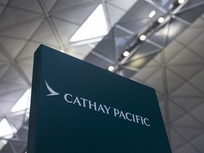 FILE - A signage for Cathay Pacific Airways at the departures hall of Hong Kong International Airport in Hong Kong, on March 8, 2023. On Tuesday, May 23, 2023, Hong Kong's Cathay Pacific Airways fired three cabin crew members after a passenger accused them of discriminating against non-English speakers, in a case that drew criticism from Chinese state media.