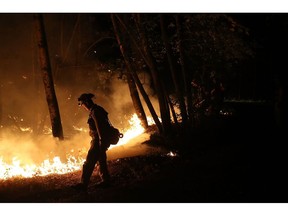 CALISTOGA, CA - OCTOBER 12: CalFire firefighter Brandon Tolp uses a drip torch during a firing operation while battling the Tubbs Fire on October 12, 2017 near Calistoga, California. At least thirty one people have died in wildfires that have burned tens of thousands of acres and destroyed over 3,500 homes and businesses in several Northern California counties.