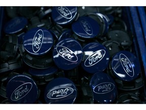 The Ford Motor Co. logo sits on wheel hub badges on the Ford Focus assembly line inside the automaker's factory in Saarlouis, Germany, on Wednesday, Sept. 25, 2019. Ford recently announced it expects 'electrified' vehicles which include mild hybrids, traditional hybrids, plug-in electric hybrids (PHEVs) and battery electric vehicles (BEVs) to make up over 50% of its passenger vehicle sales by year-end 2022. Photographer: Krisztian Bocsi/Bloomberg