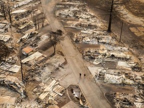 PHOENIX, OR - SEPTEMBER 10: In this aerial view from a drone, people walk through a mobile home park destroyed by fire on September 10, 2020 in Phoenix, Oregon. Hundreds of homes in the town have been lost due to wildfire.