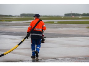 A ground crew worker holds a fuel nozzle as an Airbus A350 passenger plane, operated by Air France-KLM, fills up with sustainable aviation fuel (SAF) on the tarmac at Charles de Gaulle airport in Roissy, France, on Tuesday, May 18, 2021. Airbus SE will buttress its moonshot plan to build a hydrogen aircraft by the middle of the next decade with an effort to power conventional jets with sustainable fuels. Photographer: Nathan Laine/Bloomberg