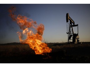 A natural gas flare burns near an oil pump jack at the New Harmony Oil Field in Grayville, Illinois, US, on Sunday, June 19, 2022. Top Biden administration officials are weighing limits on exports of fuel as the White House struggles to contain gasoline prices that have topped $5 per gallon.