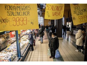 A shopper browses the counter of a cheese and dairy stall inside the Great Market Hall in Budapest.