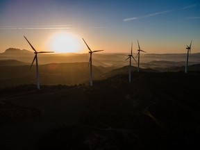 Wind turbines silhouetted against the sun