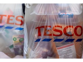 A shopper holds bags outside a Tesco supermarket, operated by Tesco Plc, in Guildford, Surrey, U.K on Tuesday, Jan. 10, 2023. Photographer: Jason Alden