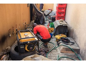A worker fixes power generator units at a repair shop in Lagos, Nigeria, on Friday, Feb. 10, 2023. Africa's most populous nation heads to the polls on Saturday, and the next president will inherit an economy and country on its knees.