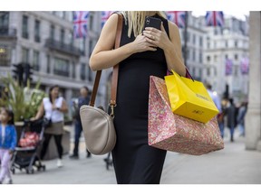 A shopper carries bags on Regent Street in London, UK, on Thursday, May 25, 2023. Photographer: Jason Alden/Bloomberg
