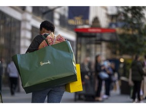 A shoppers carries a Harrods Ltd. department store shopping bag on Regent Street in London, UK, on Thursday, May 25, 2023. UK retailers saw sales jump more than expected last month, recovering from heavy rain that kept people home the month before. Photographer: Jason Alden/Bloomberg