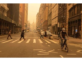 Pedestrians wear face masks as smoke from Canada wildfires blankets New York on June 7.