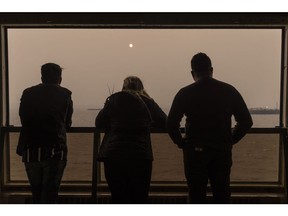 Passengers on the Staten Island Ferry look out over buildings shrouded in smoke from Canada wildfires in New York, on June 7. Photographer: Victor J. Blue/Bloomberg