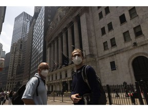 Pedestrians wear protective masks due to poor air quality from wildfires in Canada outside the New York Stock Exchange in New York, US, on Thursday, June 8, 2023. The US Northeast will continue to breathe in choking smoke from fires across eastern Canada for the next few days, raising health alarms across impacted areas.